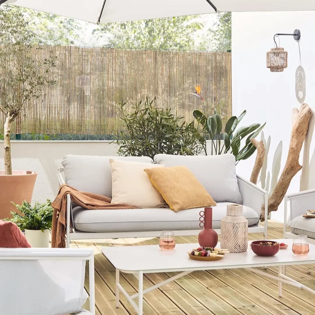 Salon extérieur avec canapé blanc et bois flotté